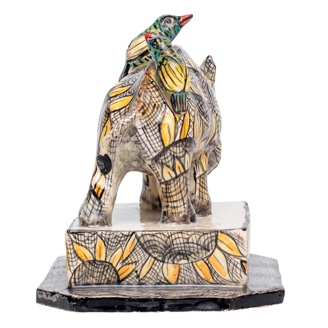 2 birds sitting on-top of a skin designed rhino sculpture
