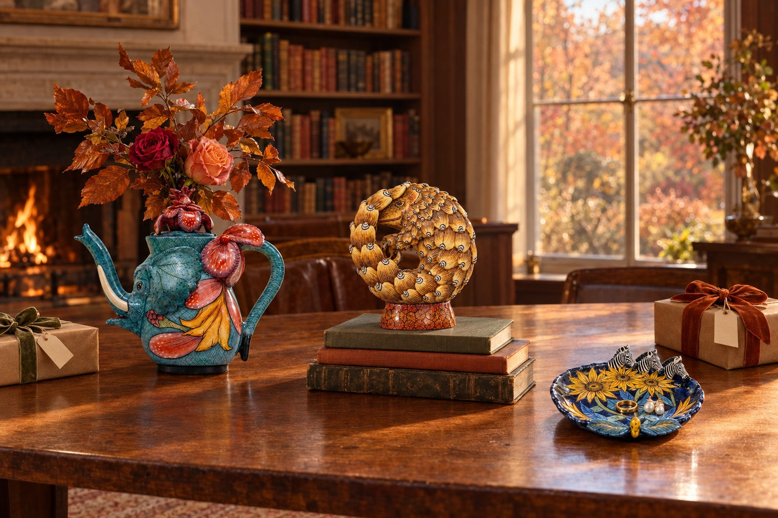 An elephant teapot, a pangolin sculpture and a zebra coin dish on a library table among wrapped presents