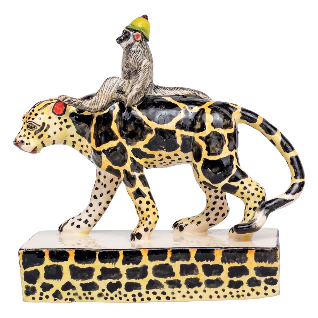 Monkey riding a black & yellow designed leopard sculpture