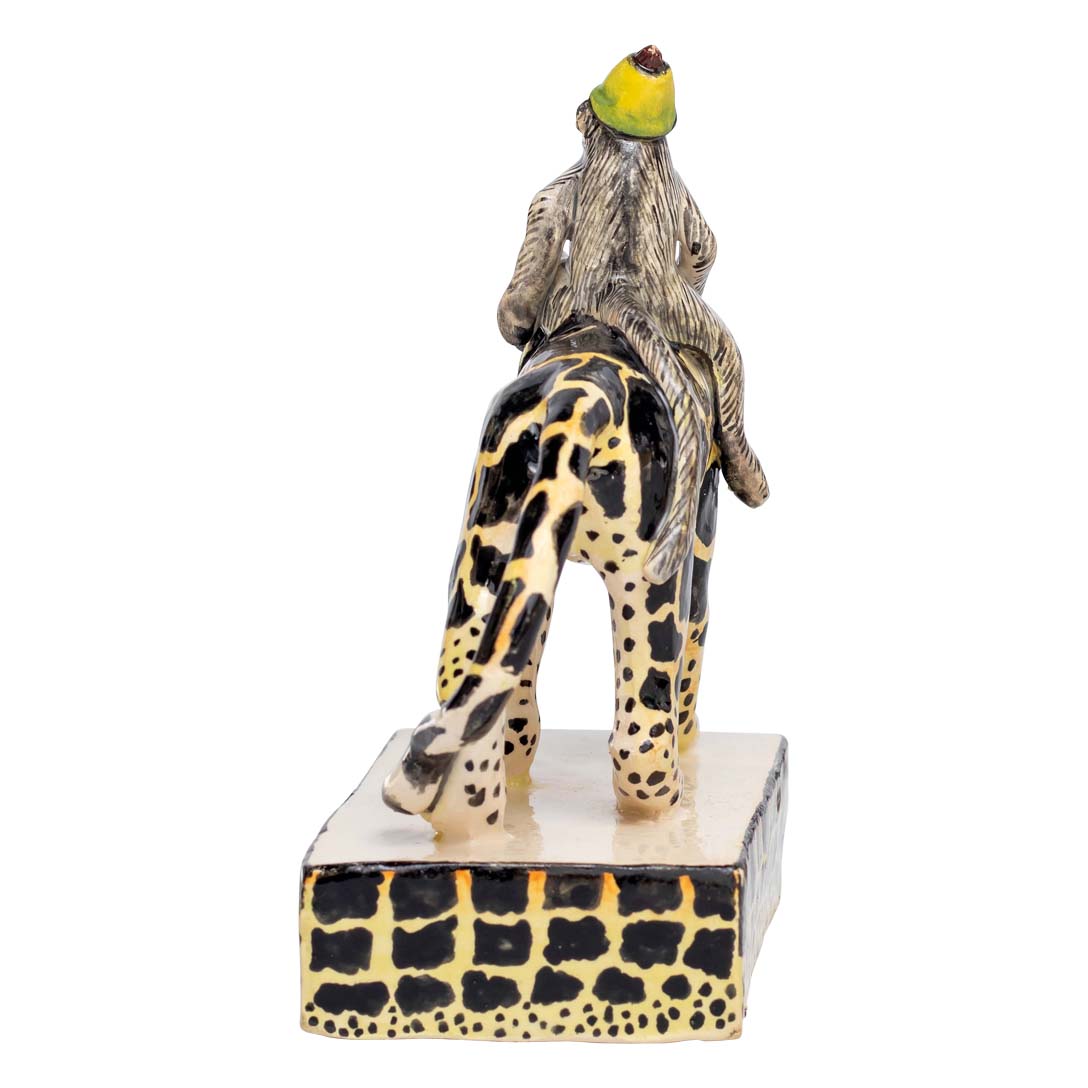 Monkey riding a black & yellow designed leopard sculpture