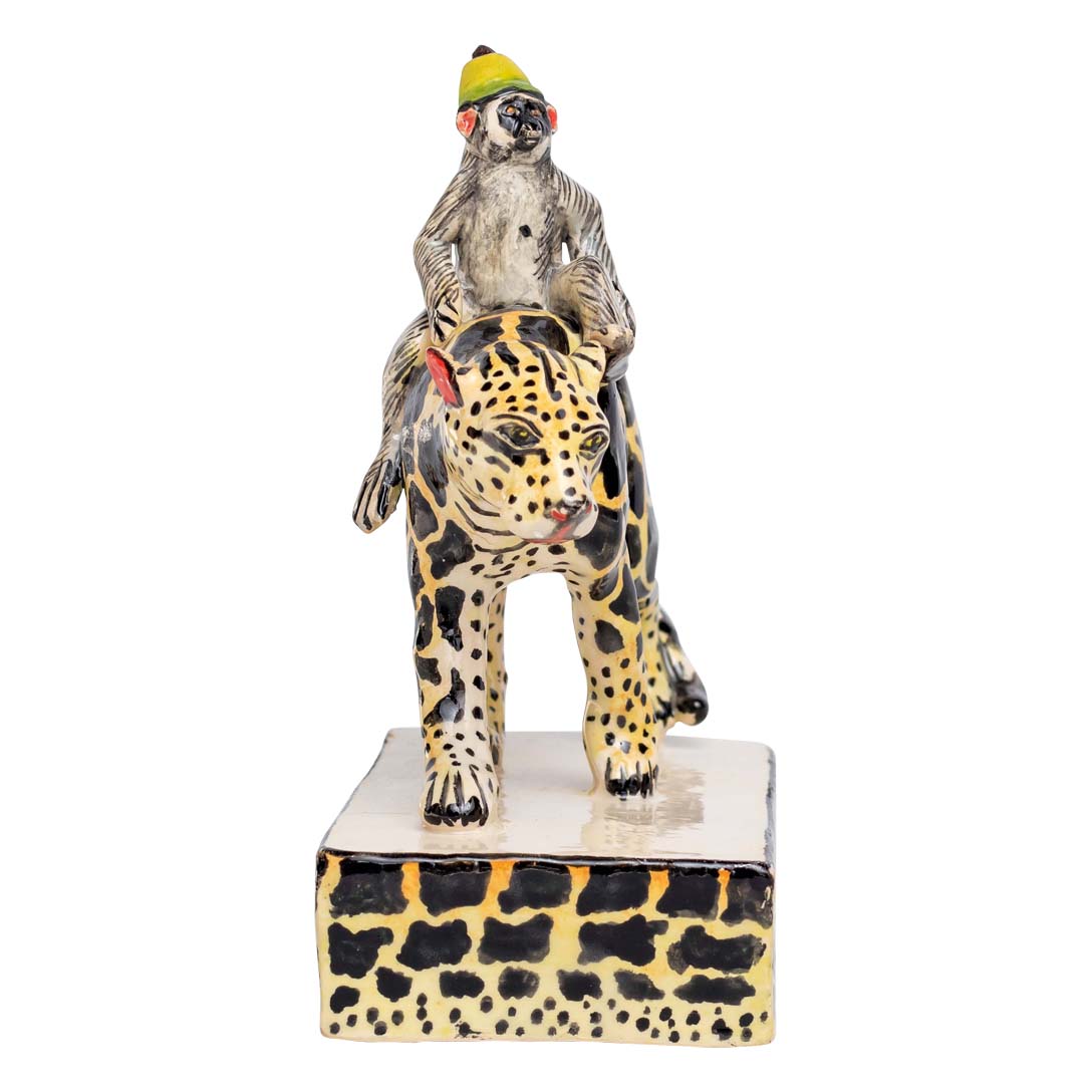 Monkey riding a black & yellow designed leopard sculpture