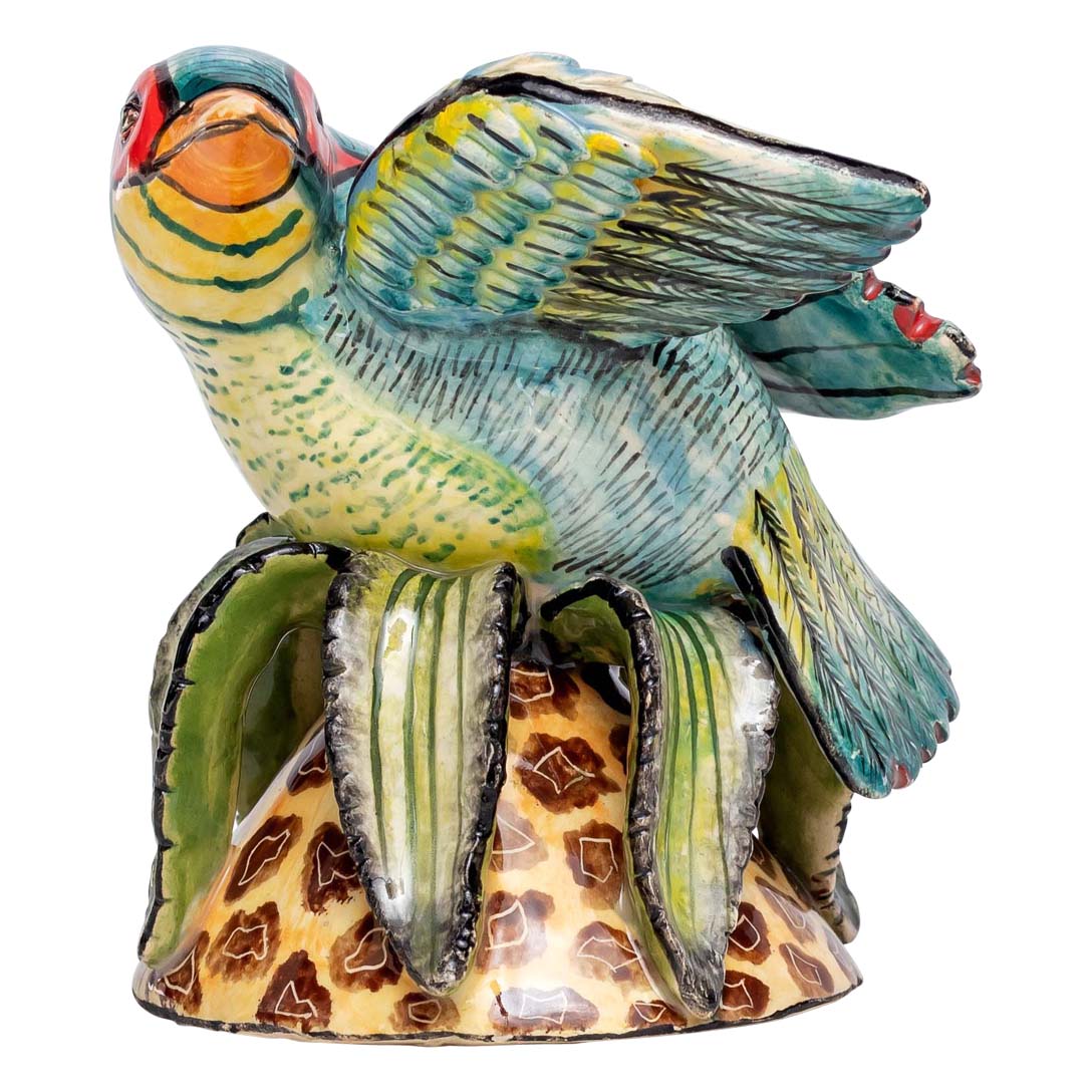 Blue designed bird sitting on-top of the flower & flapping its wings sculpture