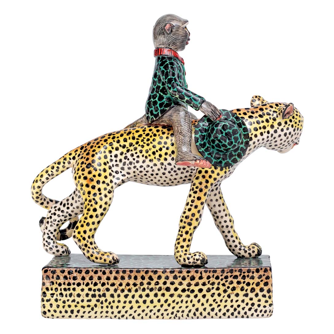 Monkey holding a hand bag riding the leopard sculpture