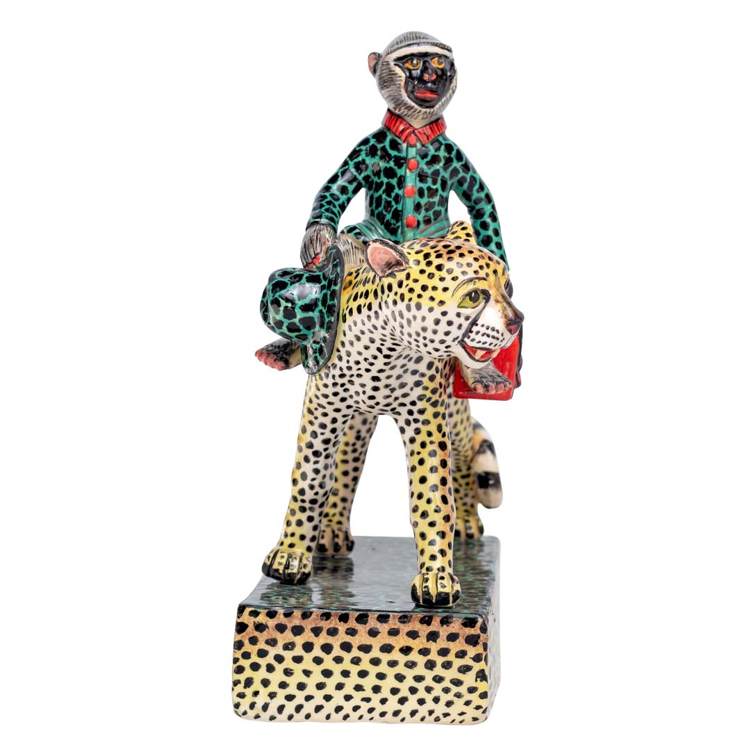 Monkey holding a hand bag riding the leopard sculpture