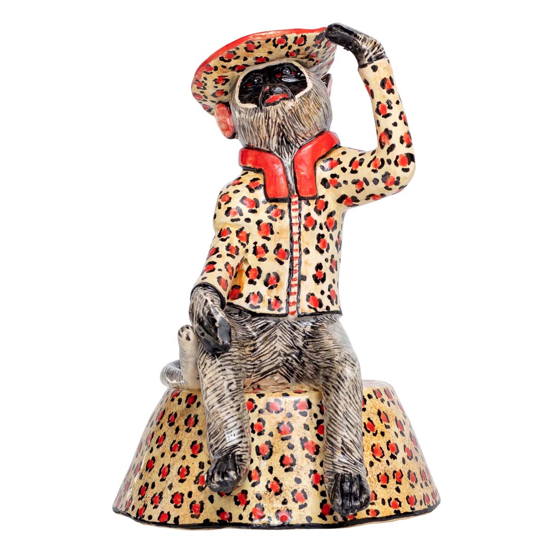 Monkey sitting & wearing a leopard colored coat & hat showing a salute signal sculpture