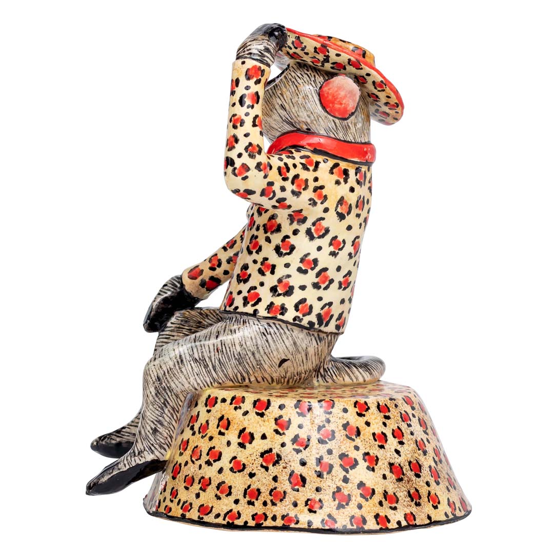 Monkey sitting & wearing a leopard colored coat & hat showing a salute signal sculpture