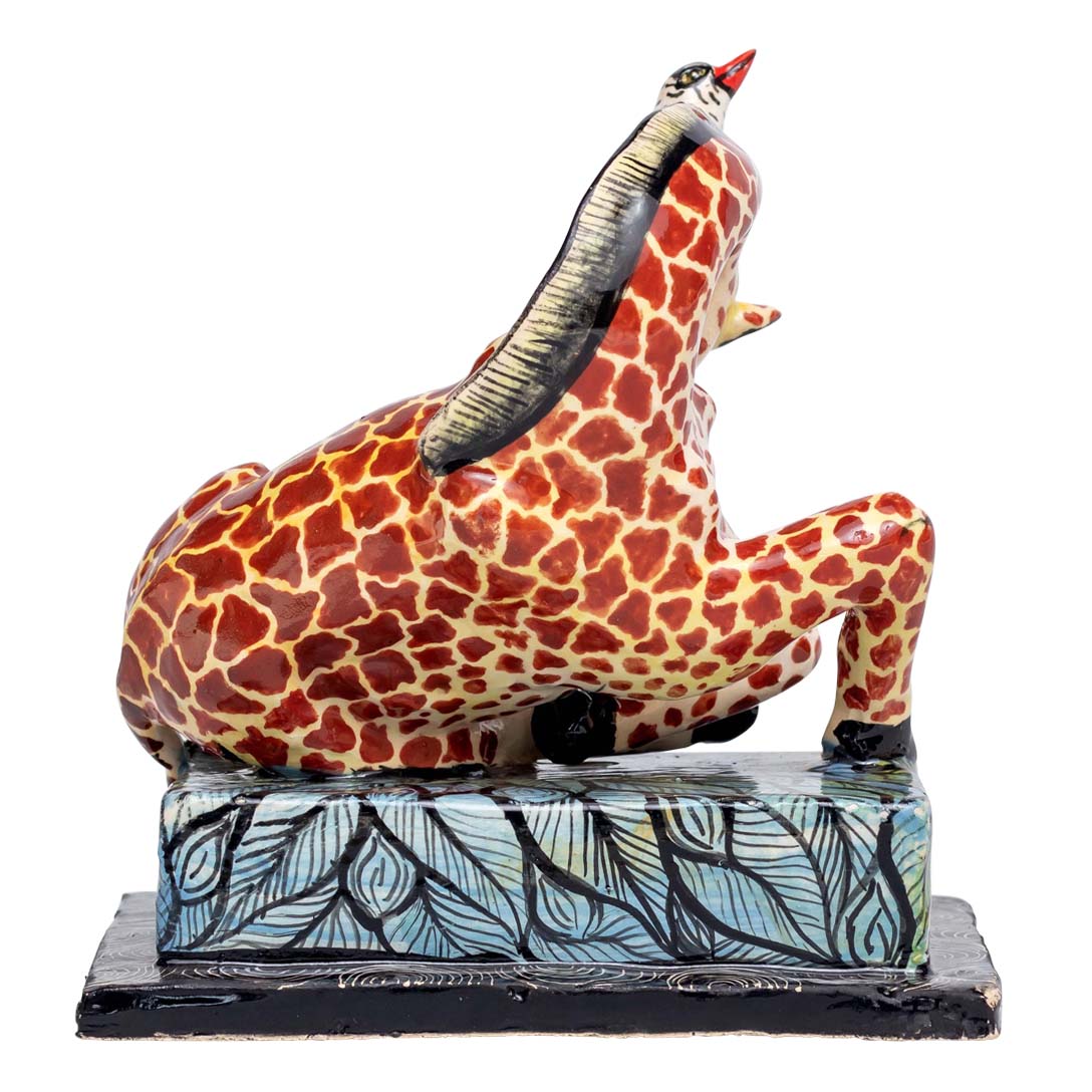 Giraffe playing with the bird sculpture