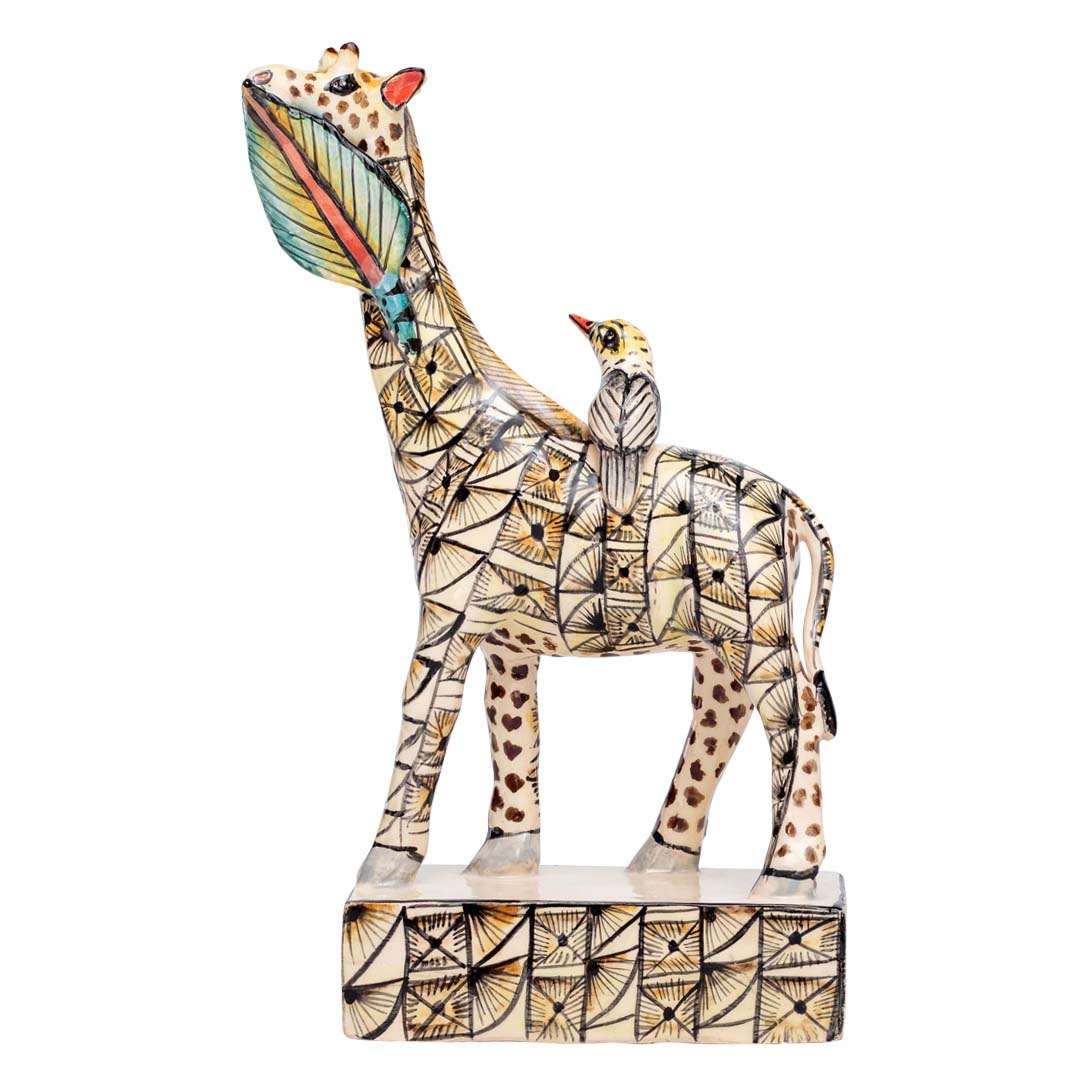 Skin designed giraffe stand eating a leaf while the bird is sitting on its back sculpture