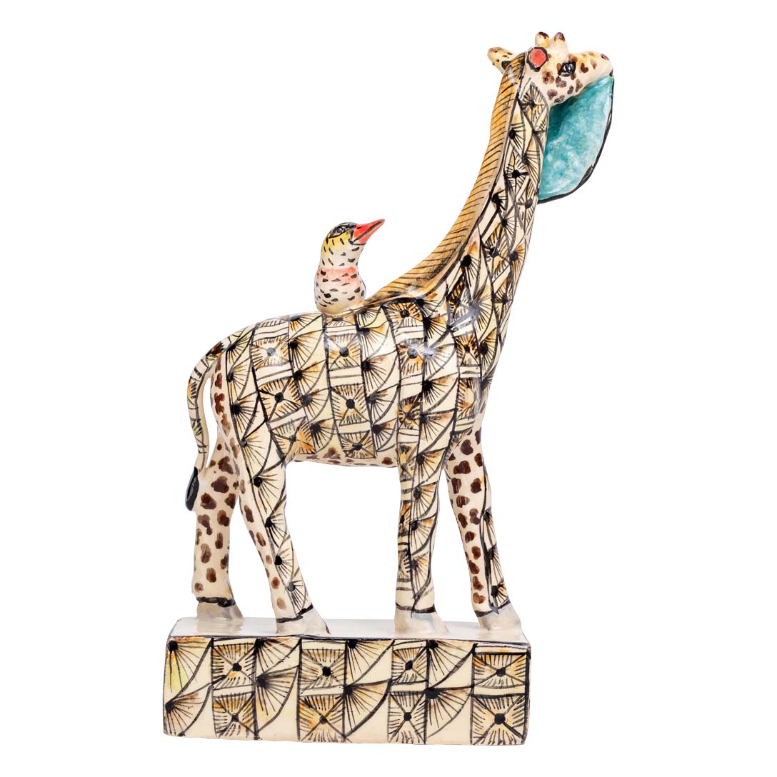 Skin designed giraffe stand eating a leaf while the bird is sitting on its back sculpture