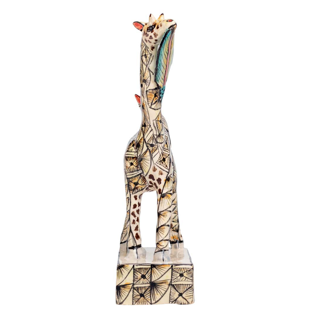 Skin designed giraffe stand eating a leaf while the bird is sitting on its back sculpture